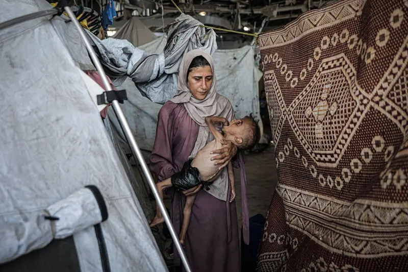 Muhammad Zakariya Ayyoub al-Matouq junto a su madre en una tienda de campaña, en Gaza. Getty Images