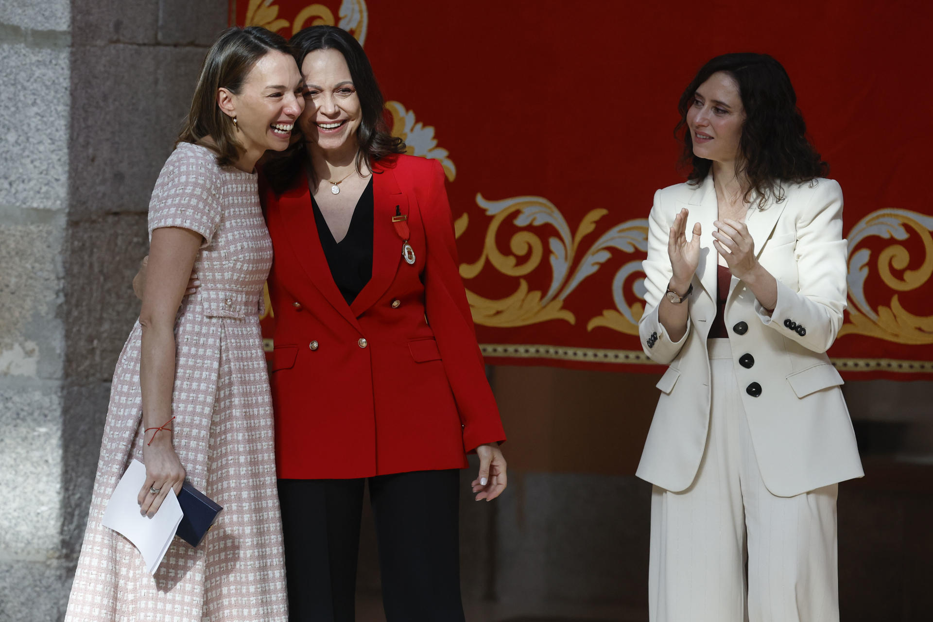 La hija de Edmundo González Urrutia, Carolina González (i), recibe en nombre de su padre la Medalla Internacional de la Comunidad de Madrid, en presencia de María Corina Machado (c) e Isabel Díaz Ayuso (d), este sábado en la Casa de Correos, en Madrid. Foto: EFE